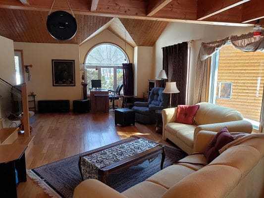 A living room with a fireplace and wooden beams.