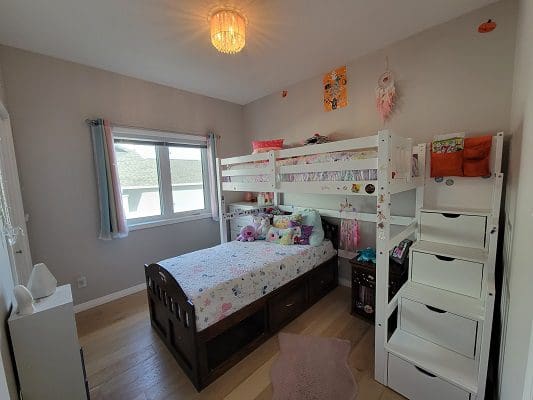 A small bedroom with a bunk bed and a desk.