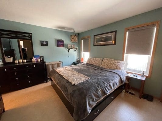 A bedroom with blue walls and a bed.