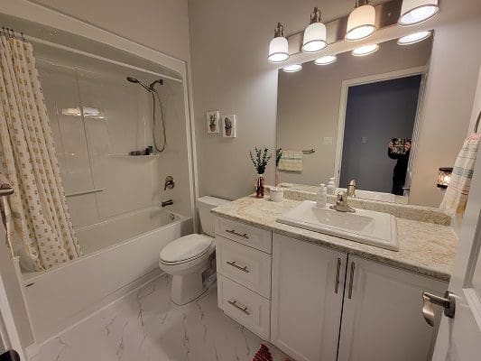 A bathroom with white cabinets and a sink.