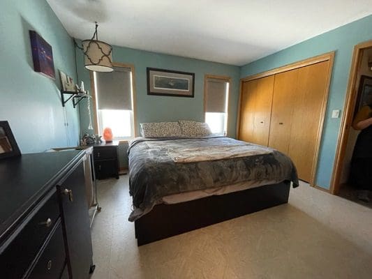 A bedroom with blue walls and a bed.