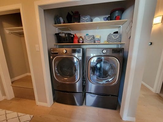 A laundry room with two washers and dryers.