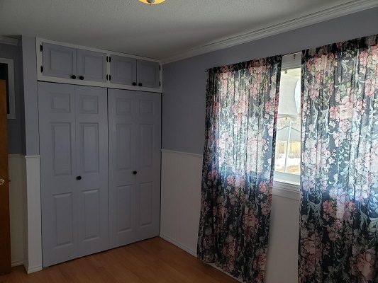 A room with purple curtains and a closet.