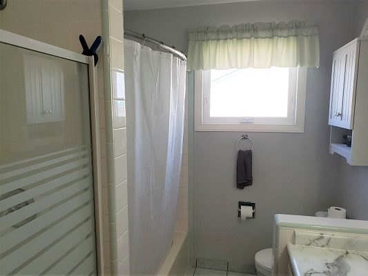 A bathroom with a shower, sink and toilet.