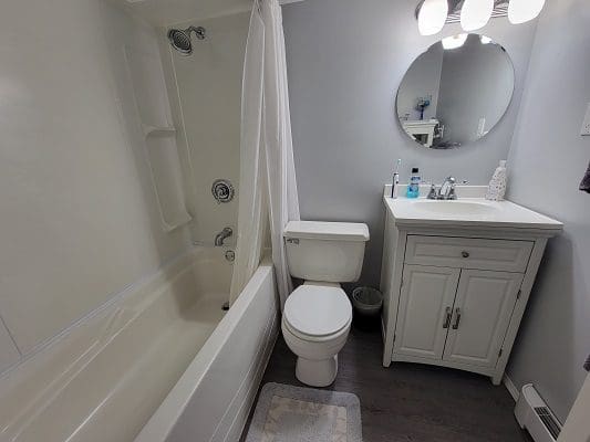 A bathroom with a toilet, sink and bathtub.