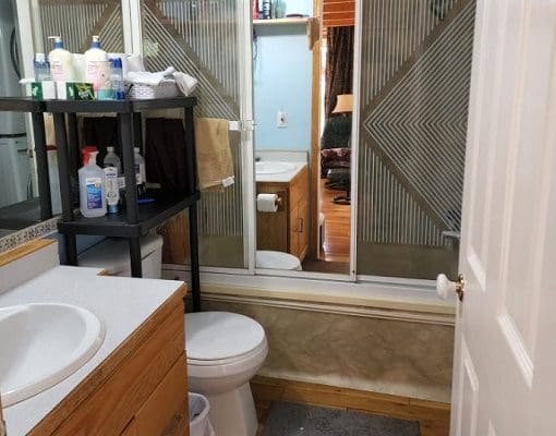 A bathroom with a toilet, sink and shower.