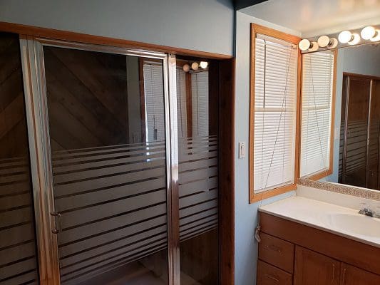 A bathroom with a shower stall and a sink.