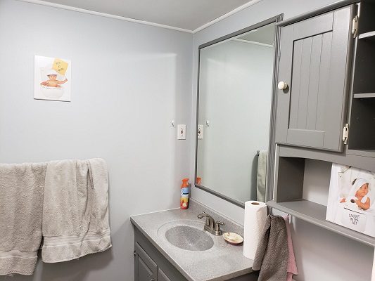 A gray bathroom with a sink and mirror.