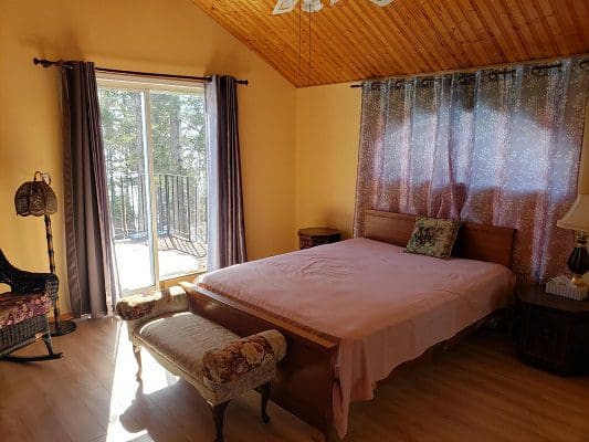 A bedroom with a bed and a sliding glass door.