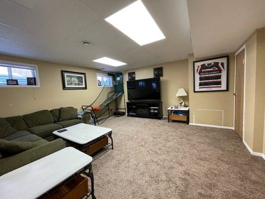 A living room with couches, a television and a tv.