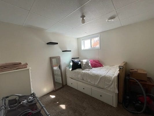 A small bedroom with a bed and a bedside table.