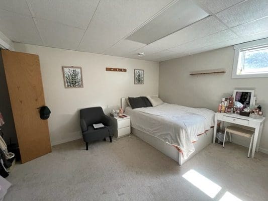 A bedroom with a bed and a desk.