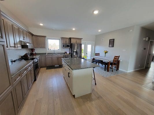 A kitchen with hardwood floors and a dining area.
