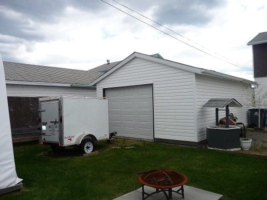 A backyard with a trailer and a fire pit.