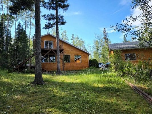 A cabin in the woods with trees surrounding it.