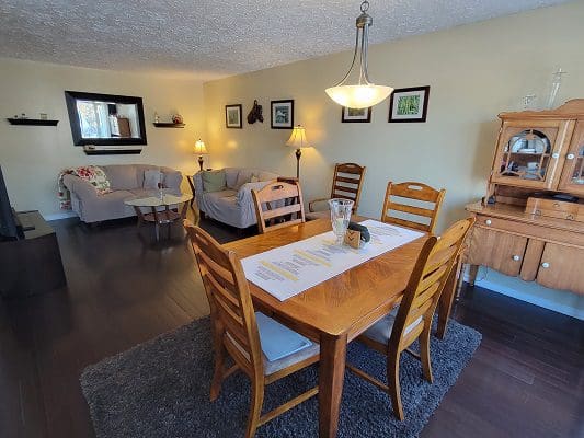 A living room with a dining table and chairs.