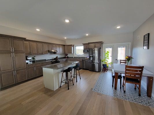 A kitchen with hardwood floors and a dining table.