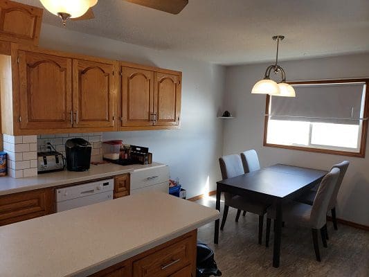 A kitchen with a table and chairs and a ceiling fan.