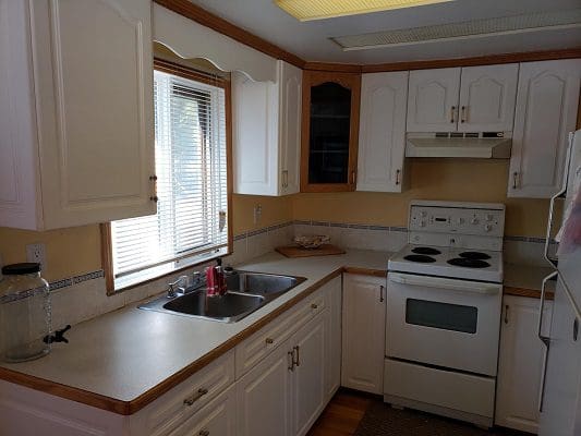 A kitchen with white cabinets and a sink.