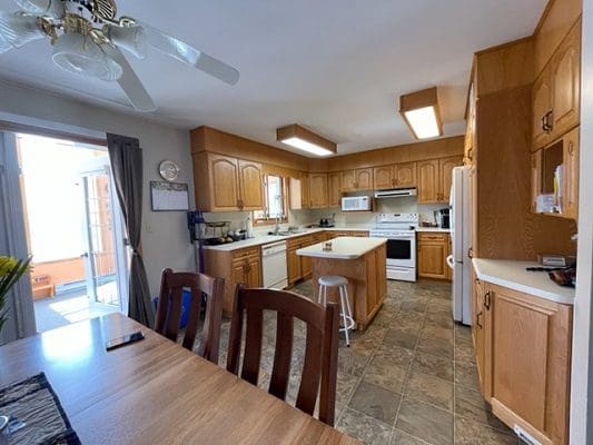 A kitchen with wood cabinets and a ceiling fan.