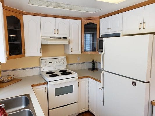 A kitchen with white cabinets and a stove.