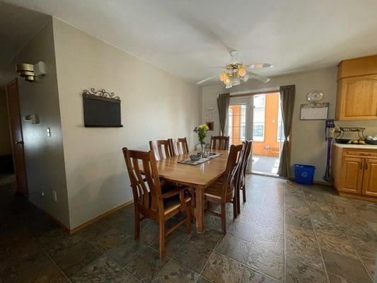 A dining room with tile floors and a ceiling fan.