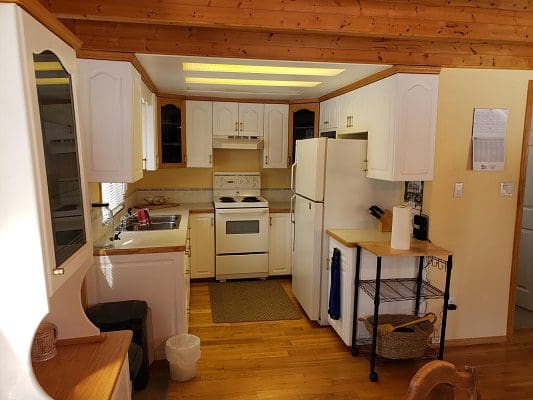 A kitchen in a log cabin with wooden floors.