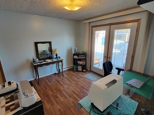 A room with a desk and a sewing machine.