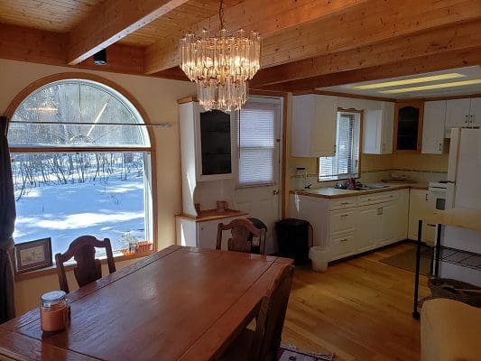 A kitchen with a dining table and chairs.