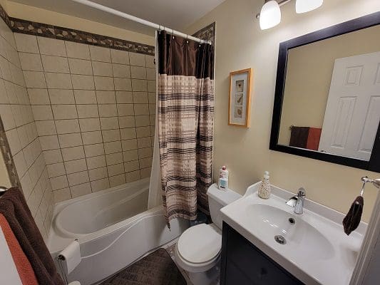 A bathroom with a toilet, sink and shower.