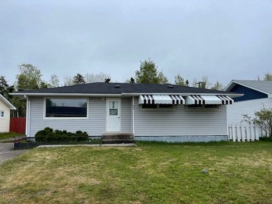 A house with a black awning in front of it.
