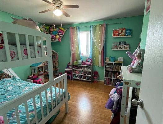 A child's bedroom with a bunk bed and a ceiling fan.