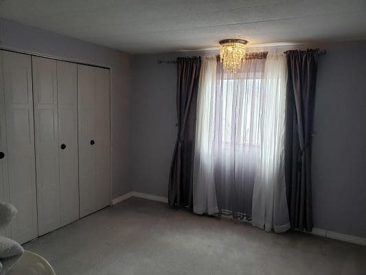 A room with curtains and a closet.