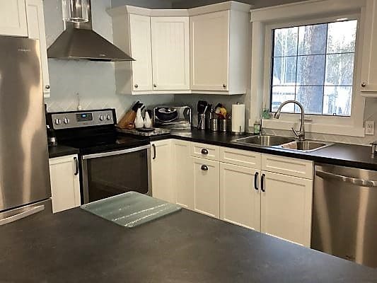 A kitchen with stainless steel appliances and white cabinets.