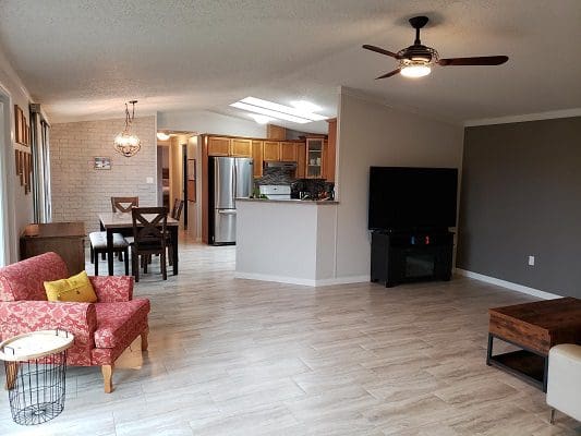 A living room with hardwood floors and a ceiling fan.