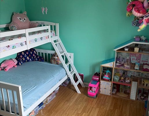 A toddler's room with a bunk bed and a ladder.