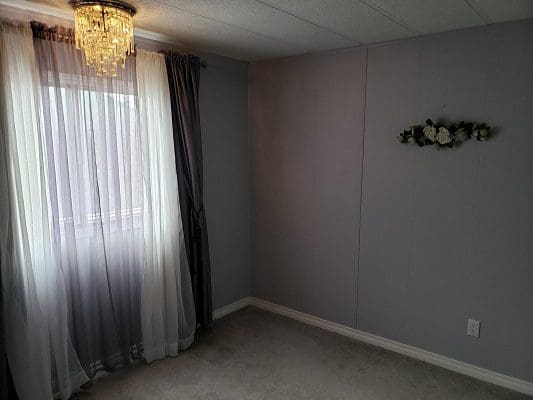 A room with purple curtains and a chandelier.