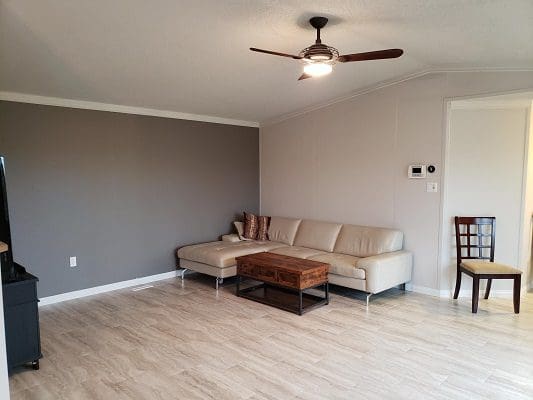 A living room with hardwood floors and a ceiling fan.