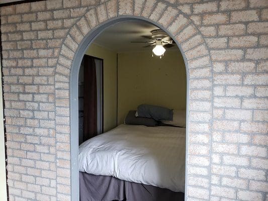 A bed in a room with a brick wall.