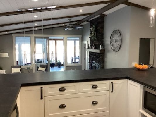 A kitchen with black counter tops and a fireplace.