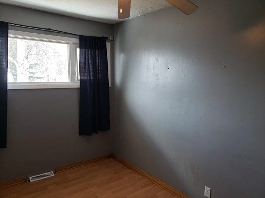 A room with gray walls and a ceiling fan.