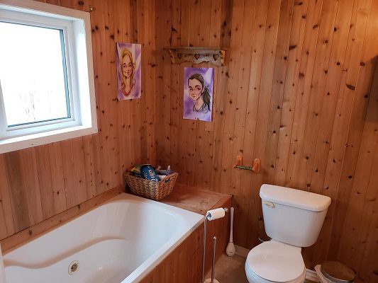 A bathroom with wooden walls and a bathtub.
