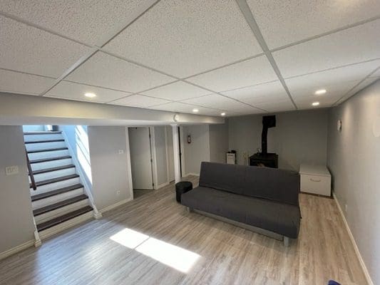 A living room with a couch and stairs.