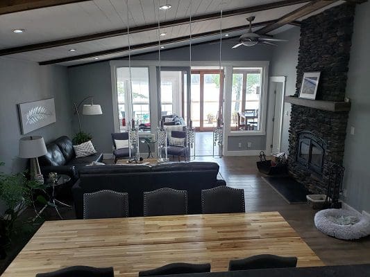 A living room with a fireplace and a dining table.