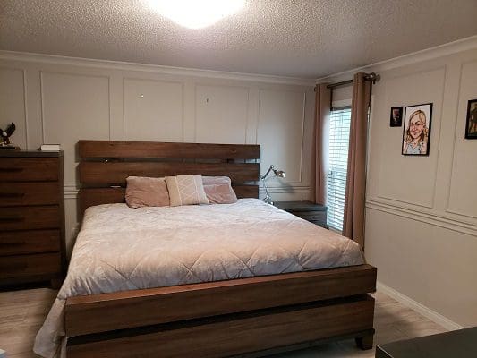 A bedroom with a bed and dresser.
