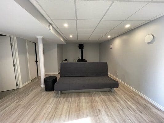 A living room with a couch and wood floors.