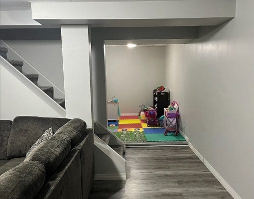 A basement with stairs and a play area.
