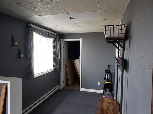 A room with gray walls and a wooden bench.