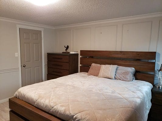 A bedroom with a bed and dresser.
