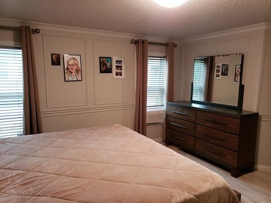 A bedroom with a bed and dresser.